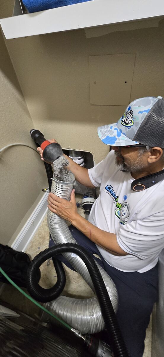 Technician inspecting and servicing flexible dryer ductwork